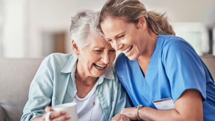 a nurse and an a senior lady smiling together