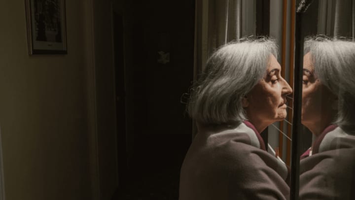 an old woman looking out the window looking melancholy 