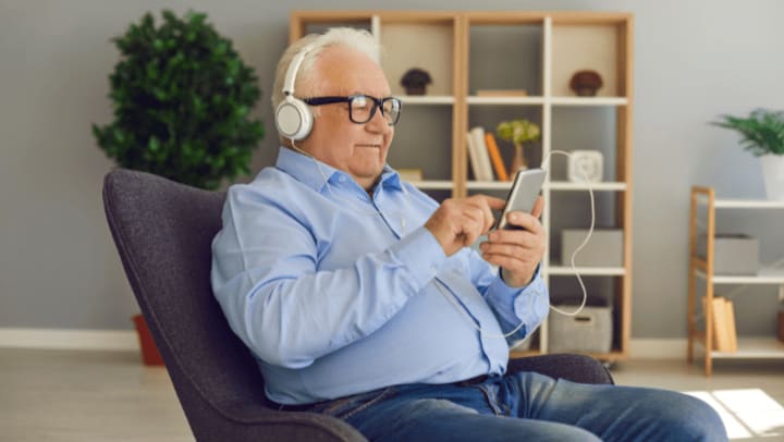 a senior men listening to music with his headphones