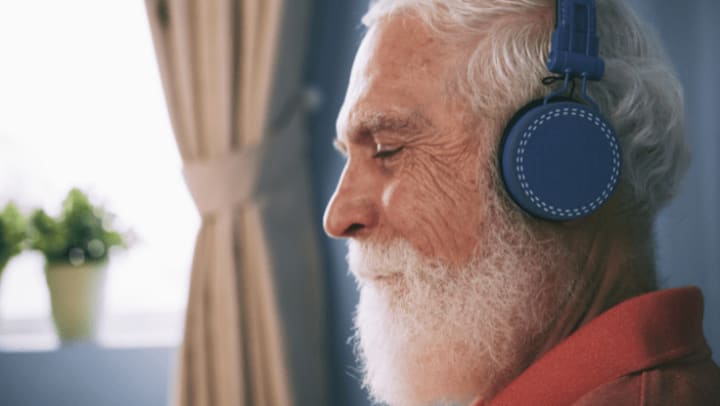 a senior men listening to music with his headphones