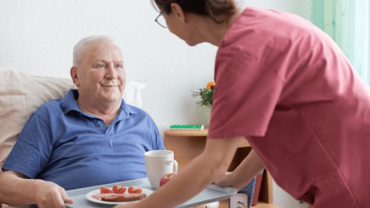 a nurse taking care from an older man 