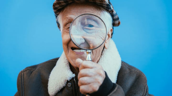 an old man looking through a magnifying glass 