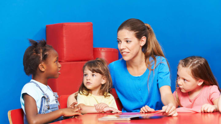 a group of girls talking to a lady 