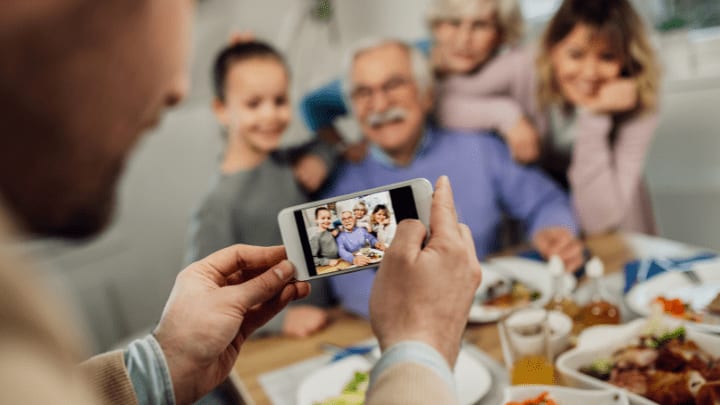 an old man taking pictures with his grandchildren 
