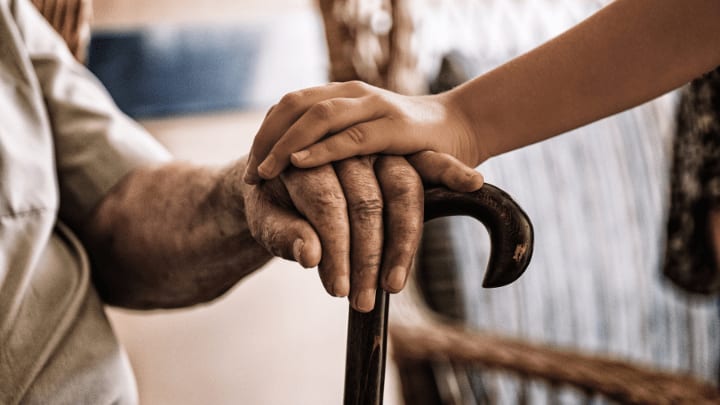 a couple holding hands with a cane 