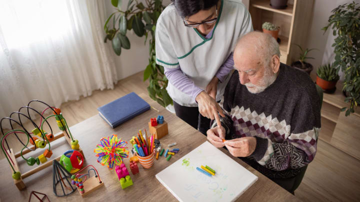a caregiver making memory activities with a senior man 