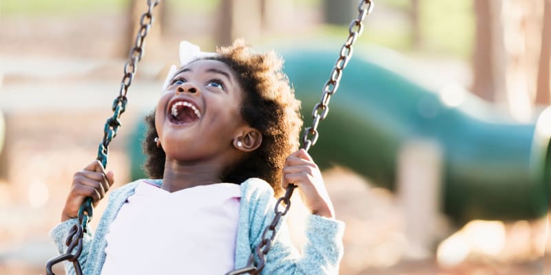 a young girl on the swing set at Forster Hills in Oceanside, California