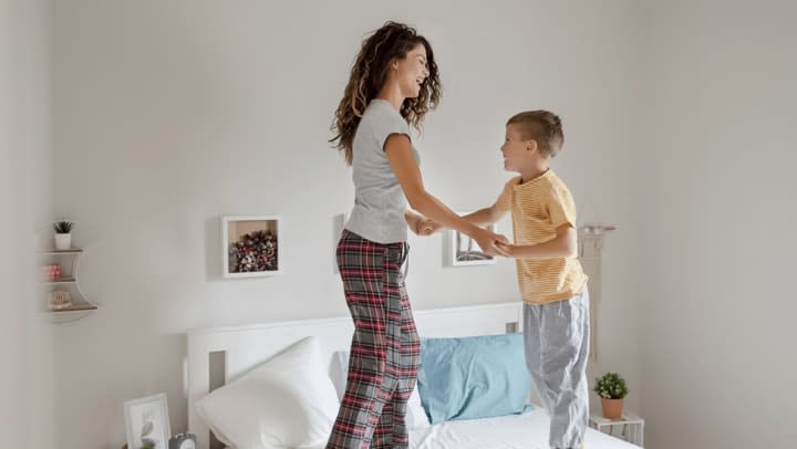 woman and boy jumping on bed