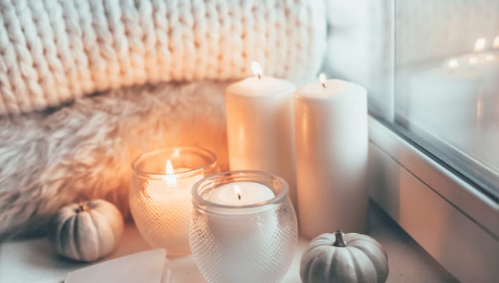 Cozy fall scene with candles, pumpkins, and blankets by a window representing seasonal home organization and secure self storage in Portland Oregon