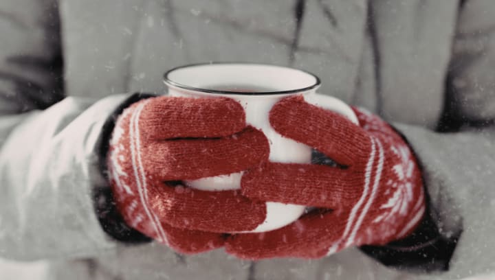 Gloved hands holding a warm mug in cold winter weather, symbolizing seasonal preparation and secure self storage solutions in Portland Oregon