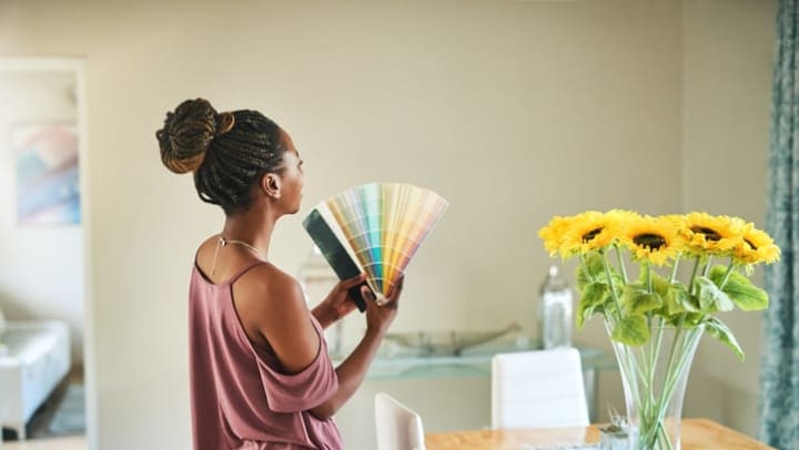 Shot of a young woman fanning out color swatches at home.