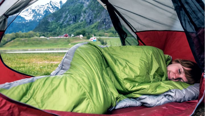 Woman sleeping happily in sleeping bag she stored at Downtown Self Storage