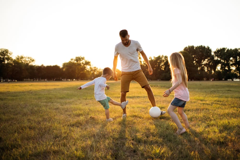 A father and his children playing in a field near Prospect View in Santee, California