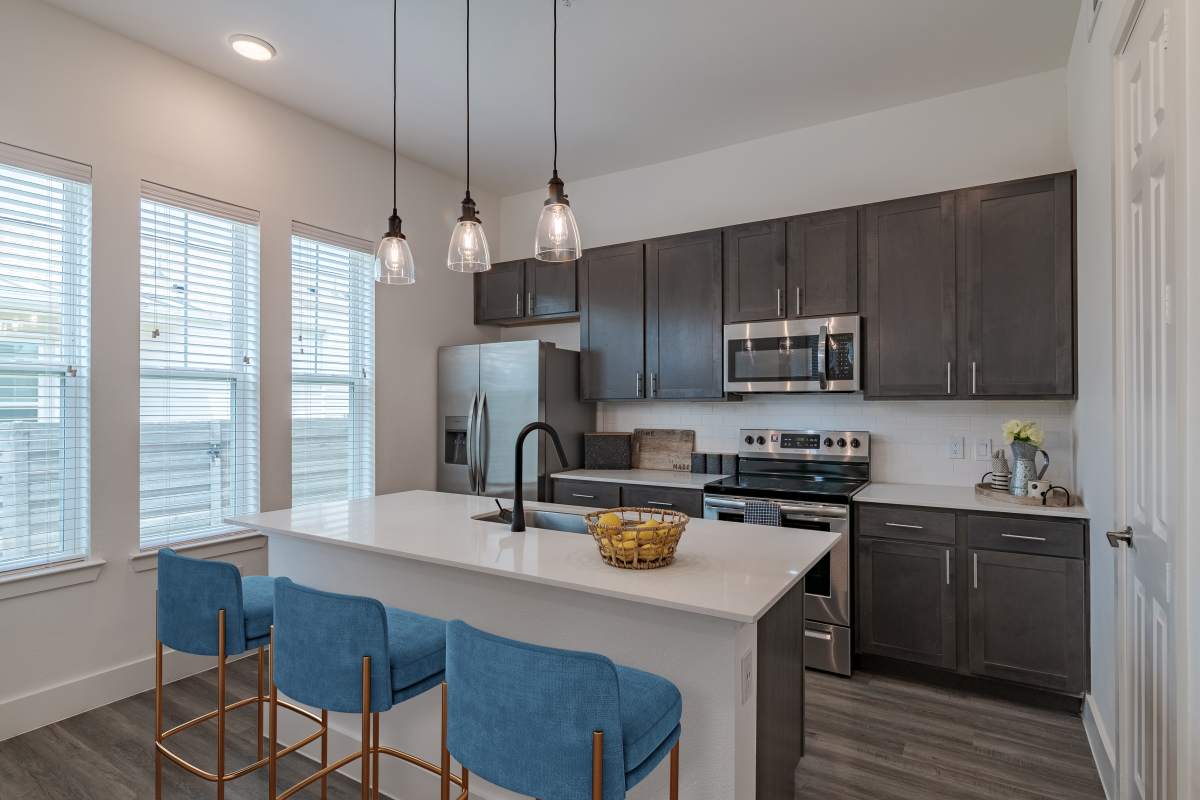 Modern kitchen with center island and new appliances at Elevate at Skyline in McKinney, Texas