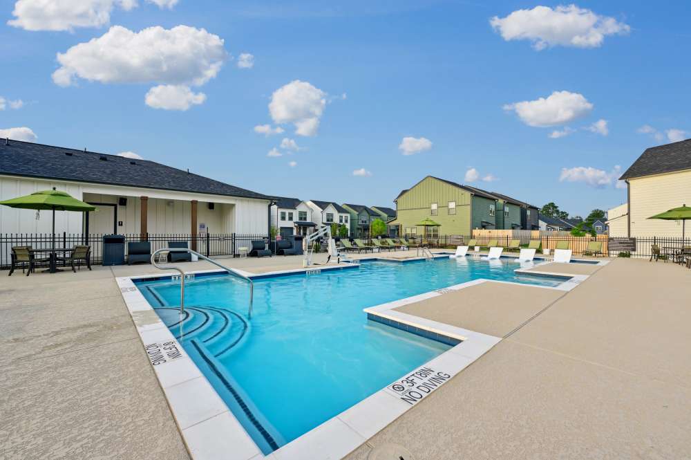 Resident sitting by pool at The Everstead at Windrose in Spring, Texas