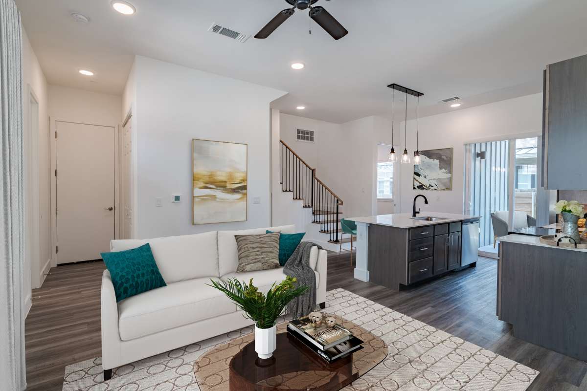 Staged living room, open to the kitchen, with walk out access at Elevate at Skyline in McKinney, Texas