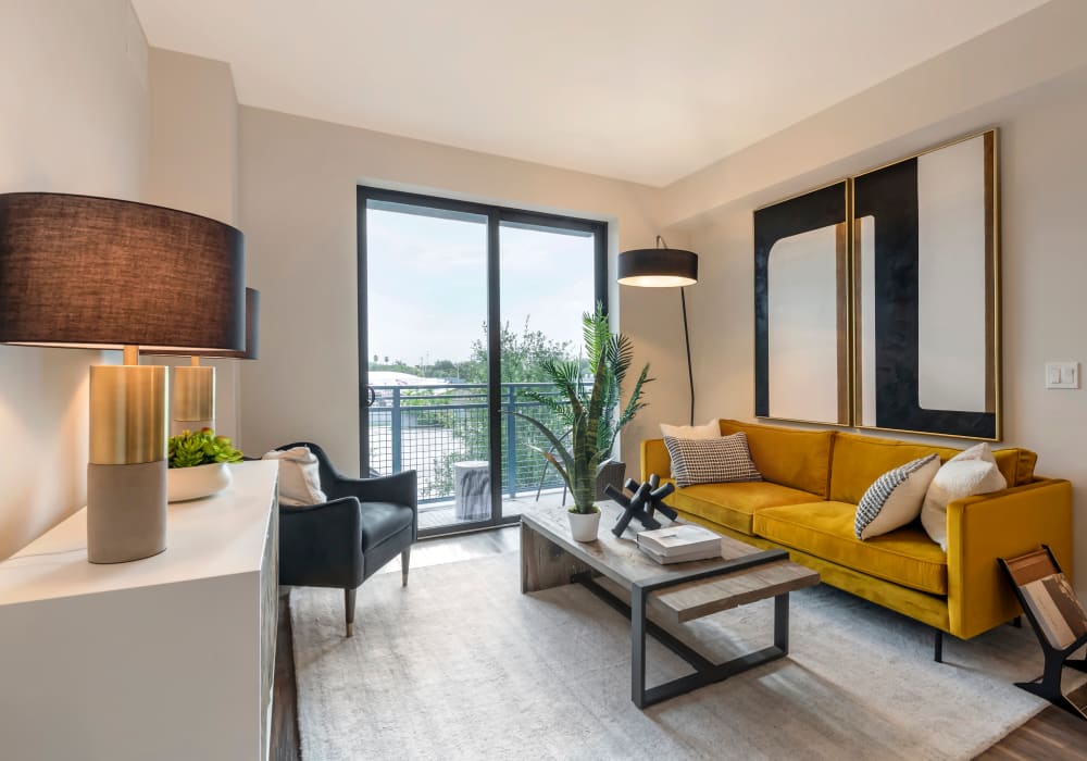 Model living room with a yellow couch at Motif in Fort Lauderdale, Florida