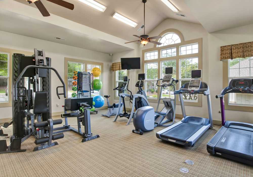 Well-equipped fitness center with cardiac and weight-lifting machines at The Crossings At Cottage Hill in Mobile, Alabama