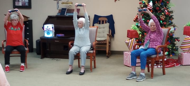 three senior adult women participating in chair exercises