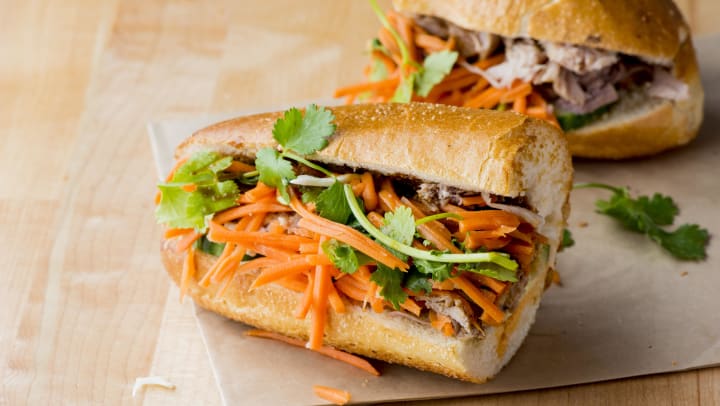 Close up of a banh mi sandwich on a wooden table  | Banh Mi sandwiches around Irving