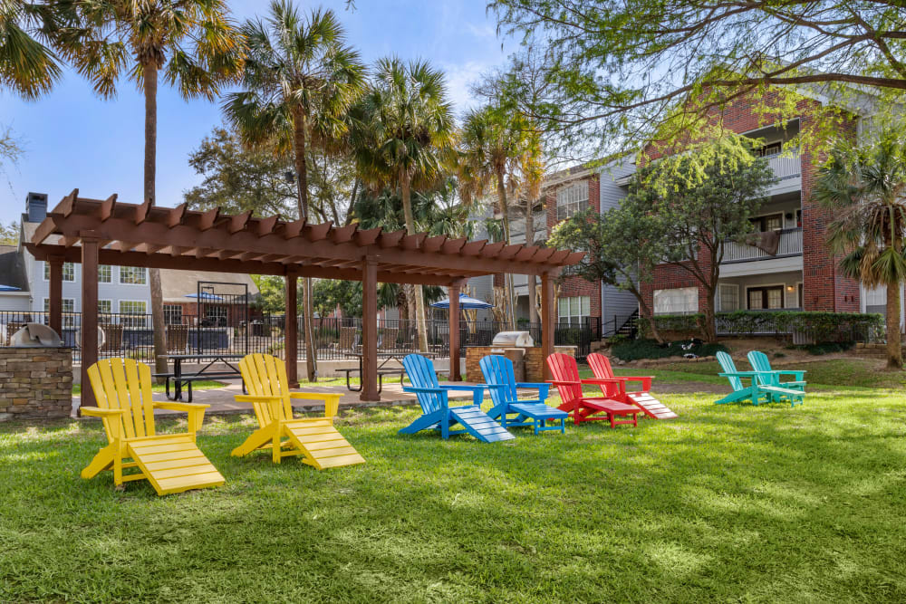 Lawn chairs and a grilling pavilion in a lush setting overlooking the lake at Foundations at Edgewater in Sugar Land, Texas