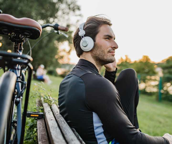 A resident sitting on a bench with headphones on and his bike next to him near Bernwood Trace in Fort Myers, Florida