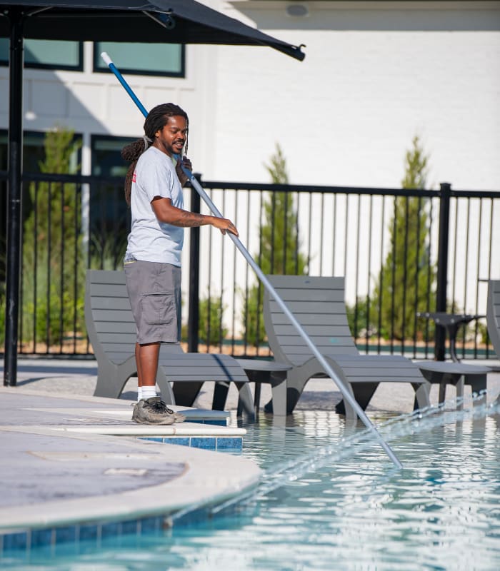 Employee cleaning a pool at Case & Associates