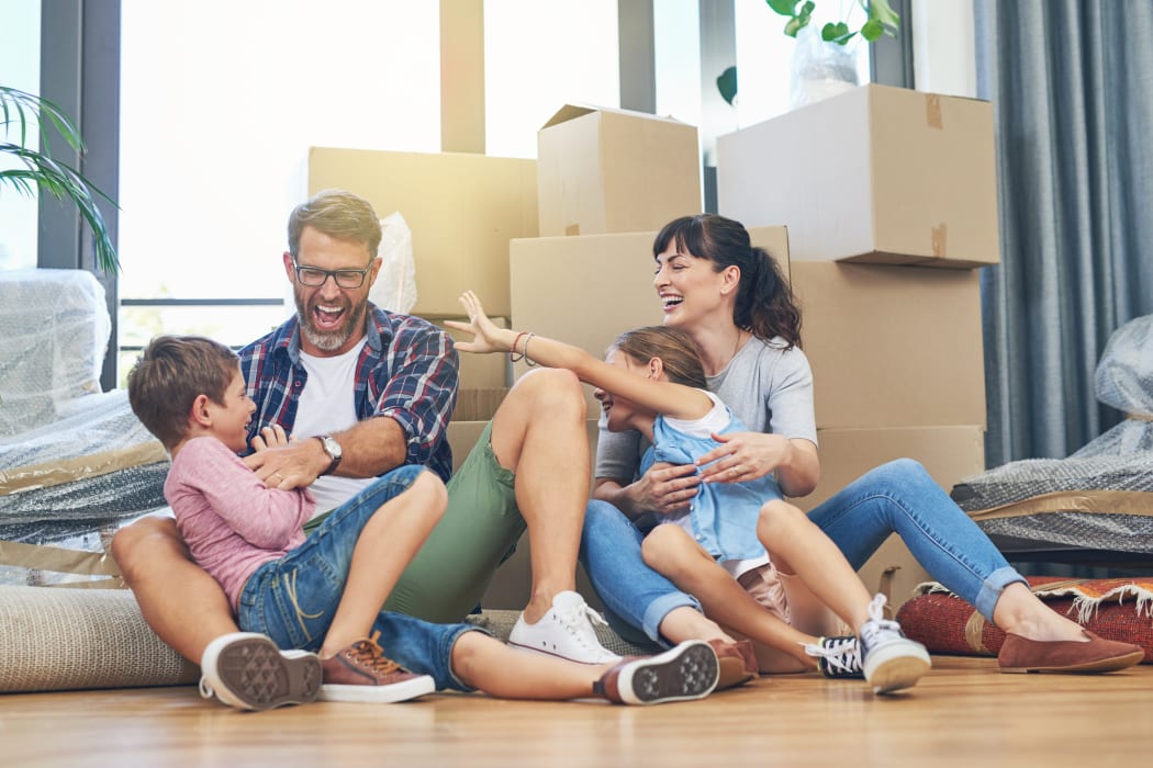Family playing together after packing boxes to be stored at Lockaway Storage in San Antonio, Texas