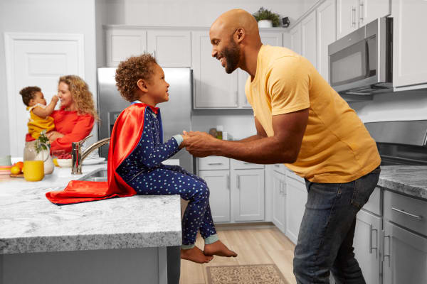 Family playing in their modern kitchen at BB Living at Eastmark in Mesa, Arizona