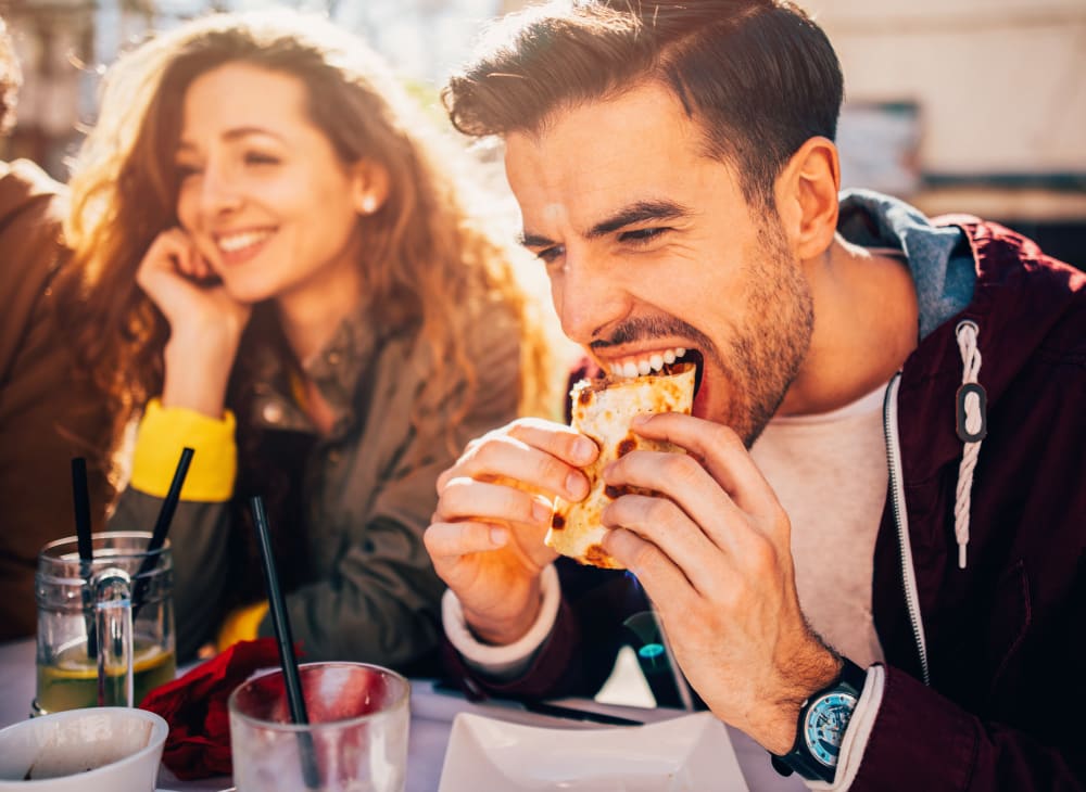 A happy couple eating their food near Paradise Gardens in San Diego, California