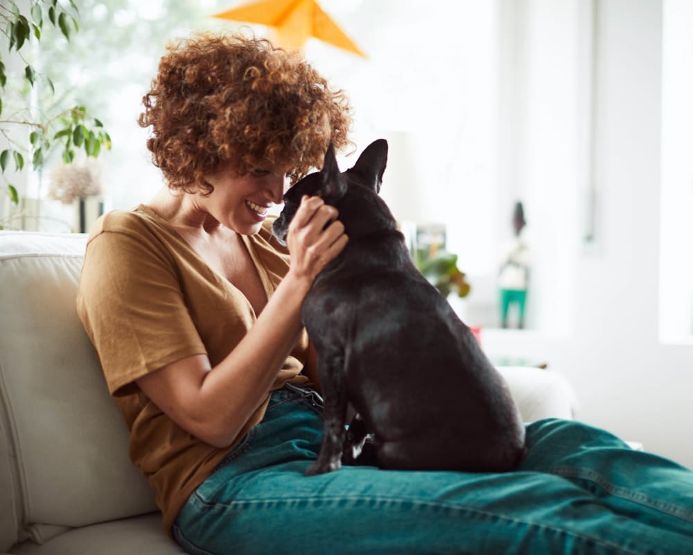 Resident giving her puppy some love in their new home at Olympus at Ross in Dallas, Texas