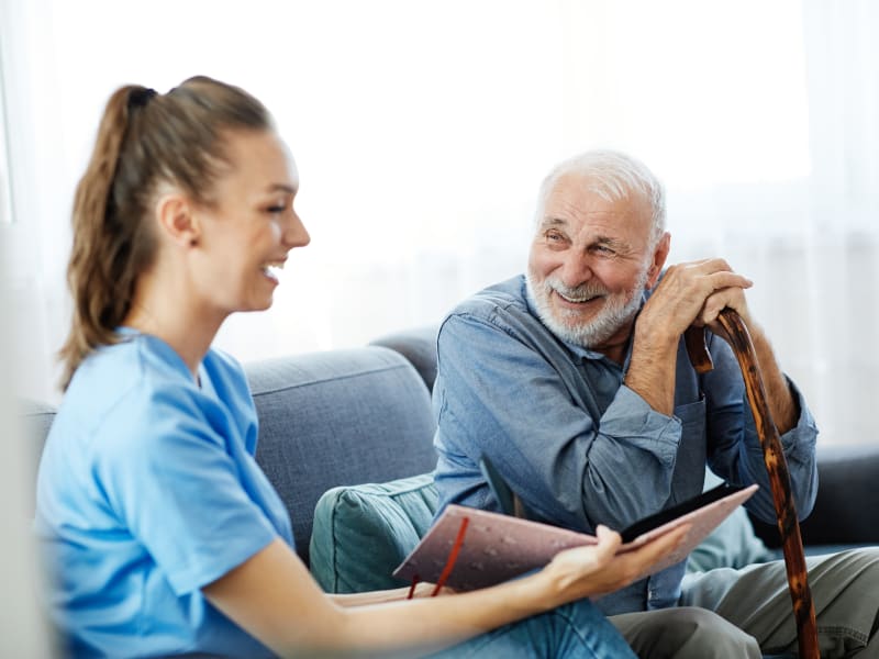 A resident looking at photos with a staff member at Timber Pointe Senior Living in Springfield, Oregon. 