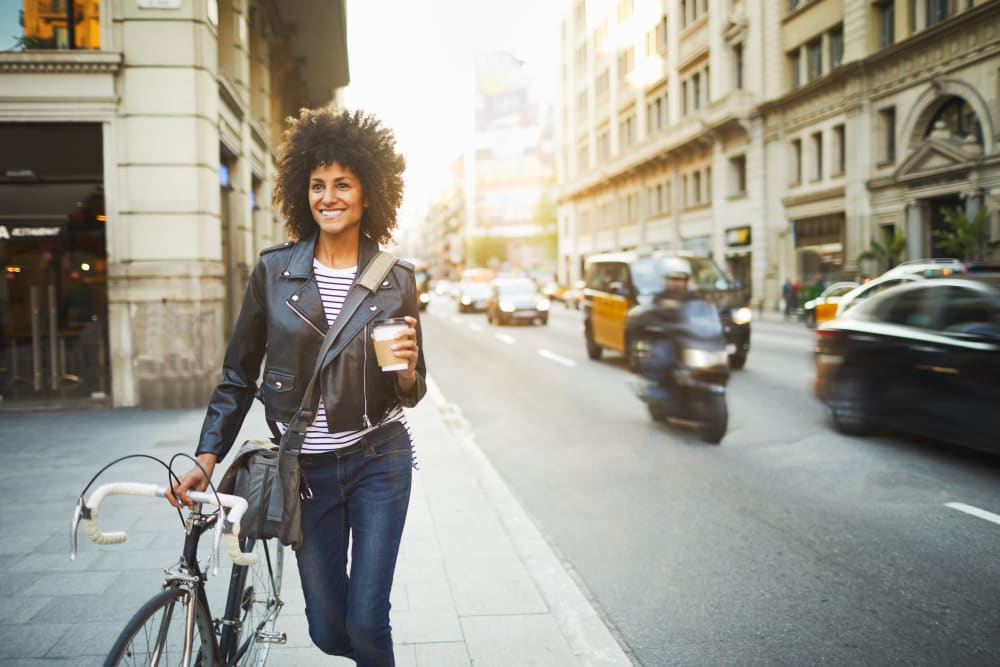 Resident enjoying her morning coffee while she strolls to work downtown near Brooklyn Yard in Portland, Oregon