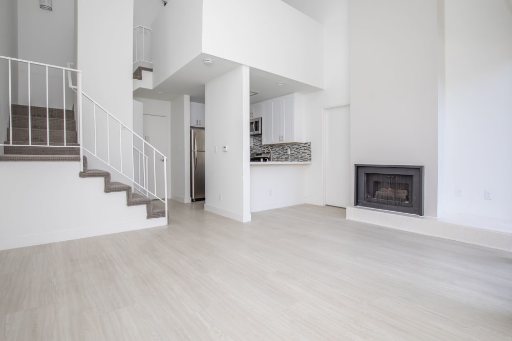 Bright model living with hardwood floors and a fireplace at Club Marina Apartments in Los Angeles, California