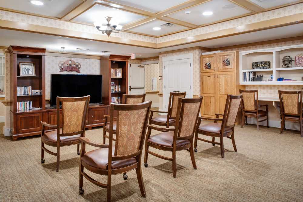 Spaious living room with television and wooden chairs at Glenncrest at Buckhead in Atlanta, Georgia