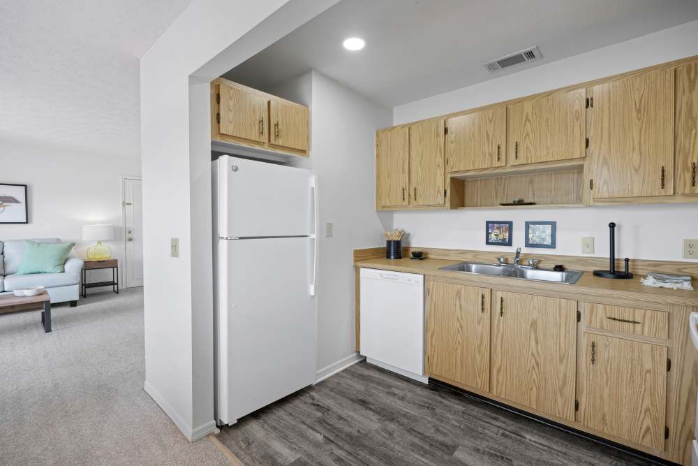 Open kitchen with bar counter, waterfall sink, stove, microwave and granite countertops at Carlton Arms Of Magnolia Valley in New Port Richey, Florida