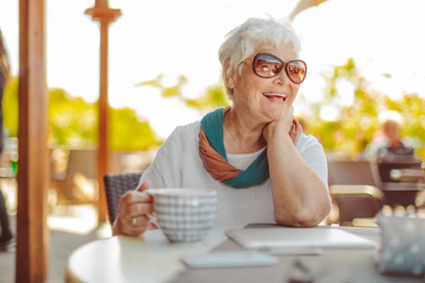 A resident enjoying a mug of coffee outside at The Pines, A Merrill Gardens Community in Rocklin, California. 