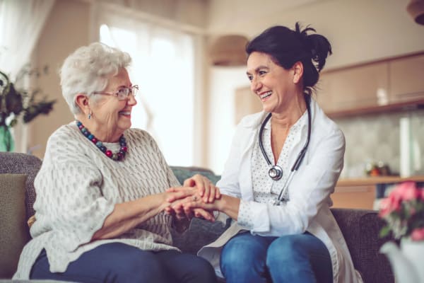 Nurse holding hands with smiling resident at Village on the Park Steeplechase in Houston, Texas