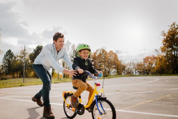 A father helping his son ride a bike near Foundry Yards in Birmingham, Alabama