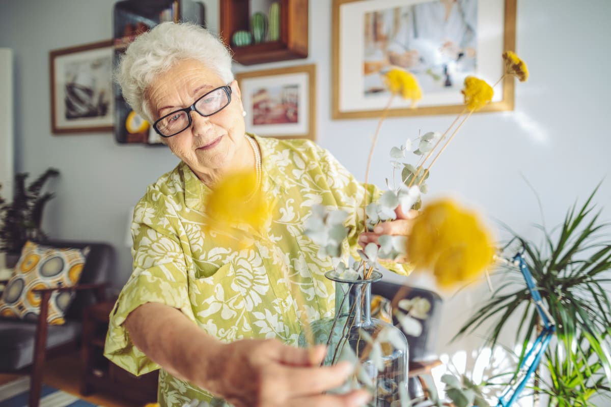 Resident arranging a flower pot at Crescent Senior Living in Sandy, Utah