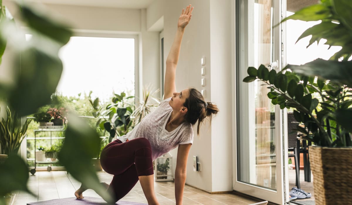 Resident practicing yoga in her serene apartment home filled with natural light at Silver Spring Station Apartment Homes in Baltimore, Maryland