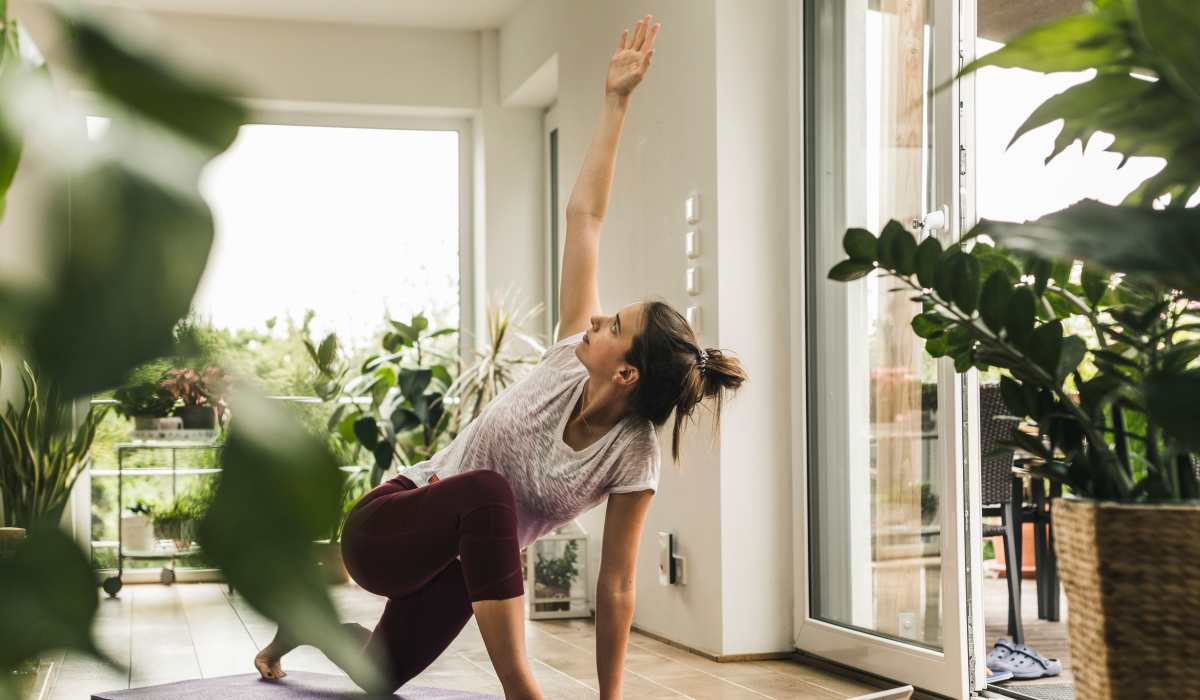 Resident practicing yoga in her serene apartment home filled with natural light at Arden at South Point Apartment Homes in McDonough, Georgia
