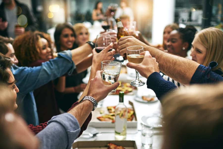 Group of resident friends out for a meal at their favorite restaurant and raising a toast to the good life at Domus on the Boulevard in Mountain View, California