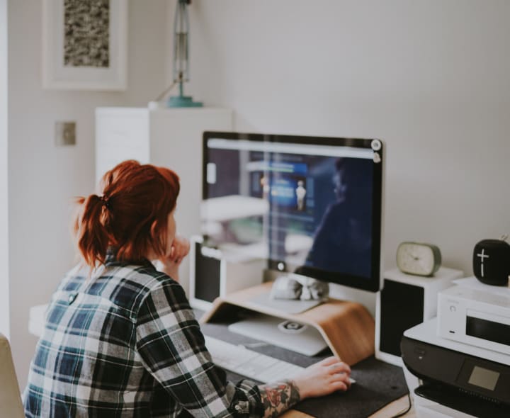 A person working at a clean and organized small desk space. 