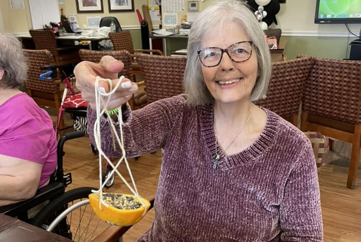 Chisholm Place Memory Care resident with hand crafted bird feeder