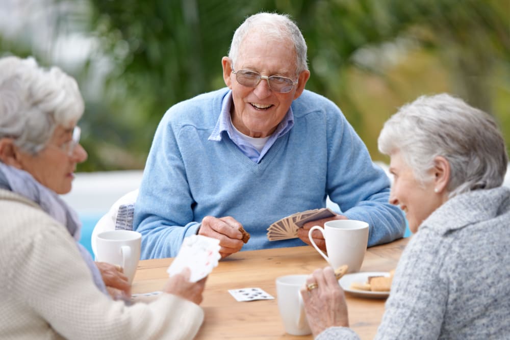 Residents playing cards on patio at Willows Landing in Monticello, Minnesota.