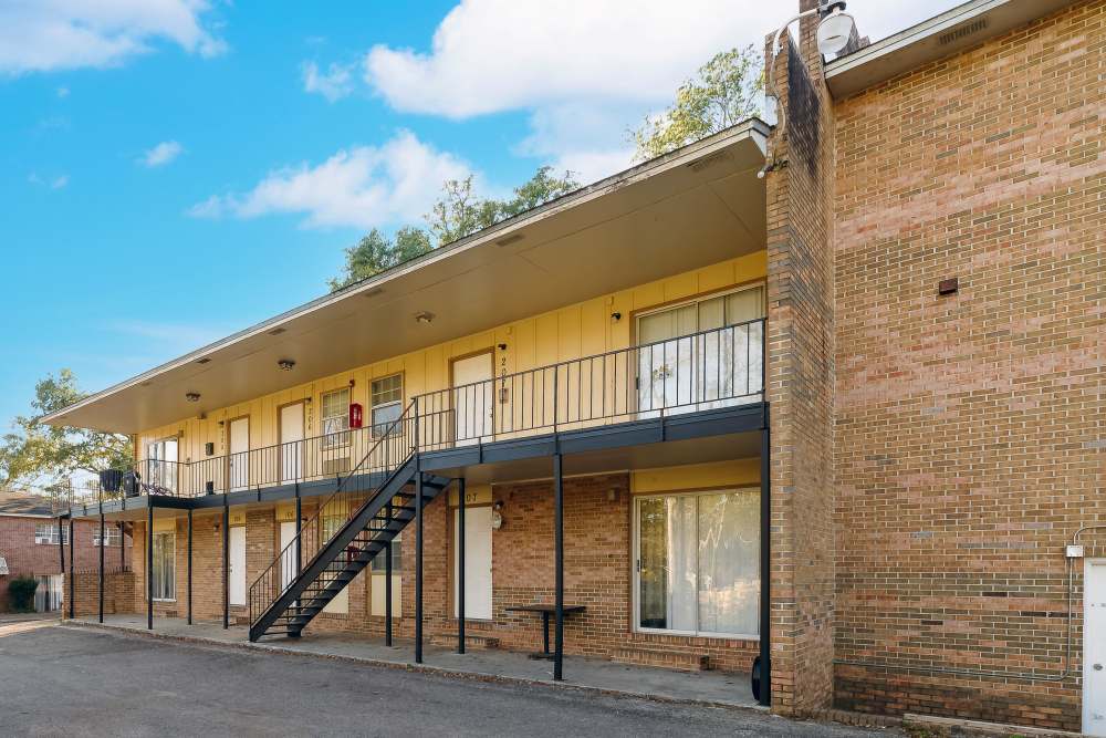 Exterior view of the apartment building with stairs leading to the above floor at Meridian Oaks in Tallahassee, Florida