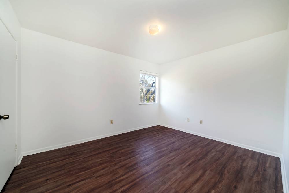 Apartment bedroom with wood flooring and window at Magnolia Terrace in Tallahassee, Florida