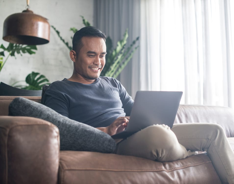 Resident filling out a form on our website on his laptop in his apartment at 2900 on First Apartments in Seattle, Washington