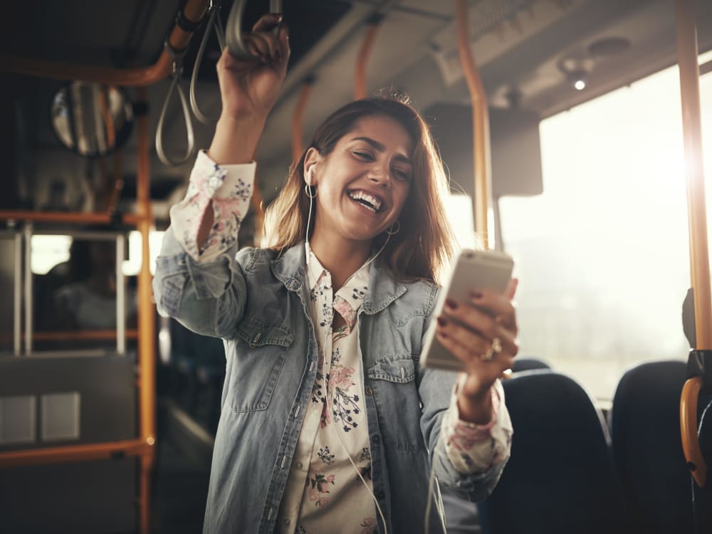 Resident riding a Metro and laughing at something on her social feed near Tower 801 in Seattle, Washington